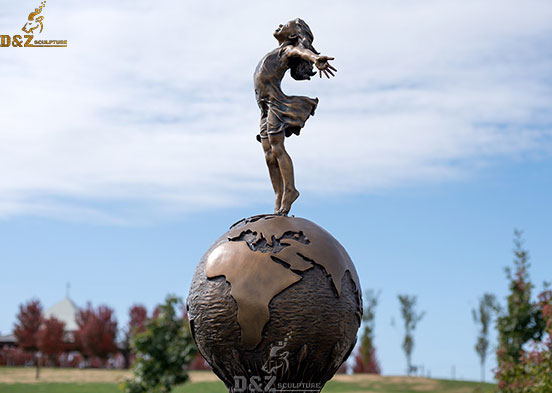 Life szie a smiling girl staning on the the globe bronze Joyful empowerment statue