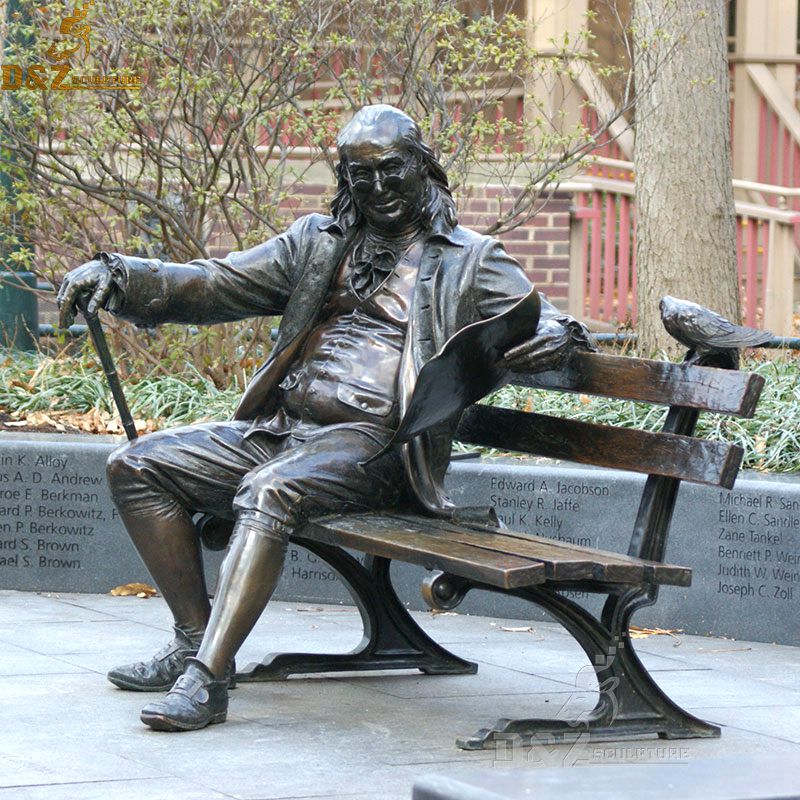 Public art bronze sculpture of Benjamin Franklin sitting on a bench reading an issue of the Pennsylvania Gazette